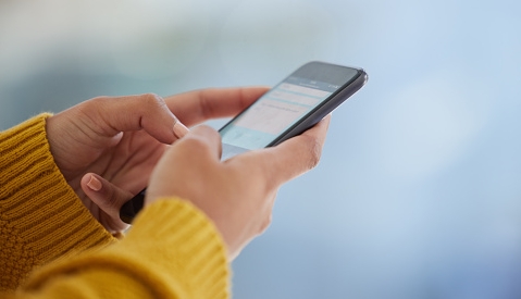 Hands typing a message on a phone